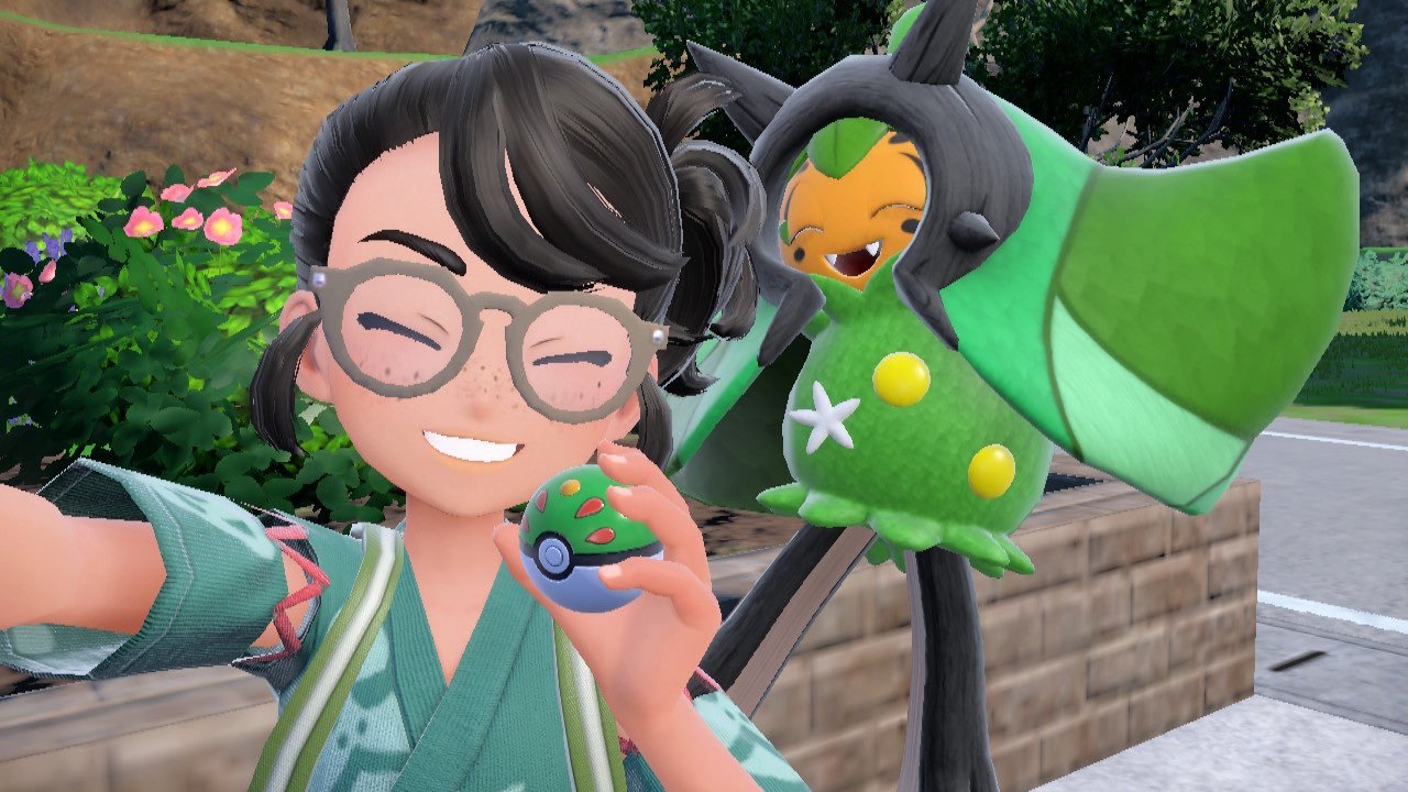 A screenshot of Pokémon Scarlet & Violet: The Teal Mask in selfie style.  The player holds a camera in one hand and a Friend Ball in the other.  Ogerpon is behind the player, jumping into the air.  Both are smiling widely.