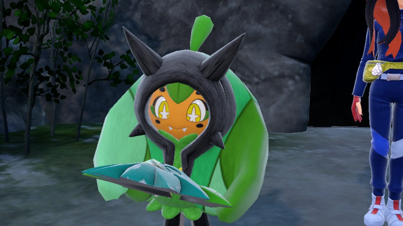 Pokémon Scarlet & Violet: The Teal Mask screenshot showing Ogerpon holding Teal Mask and looking at her lovingly.