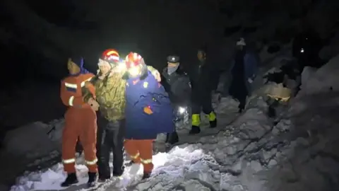 Reuters. The hike is supported by two staff rescued staff when it makes a snow slope on a snowy evening.