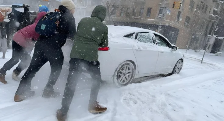 A weather map showing a low-pressure system developing off the East Coast of the United States, indicating potential snow and high winds.