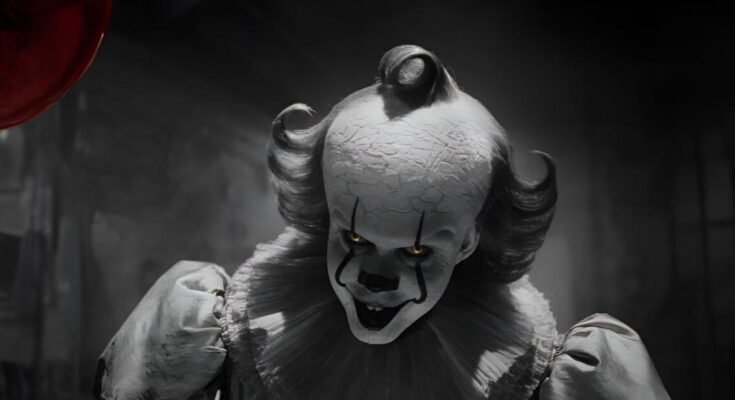 Bill Skarsgård as Pennywise in It Welcome to Derry, smiling menacingly with faded clown makeup.